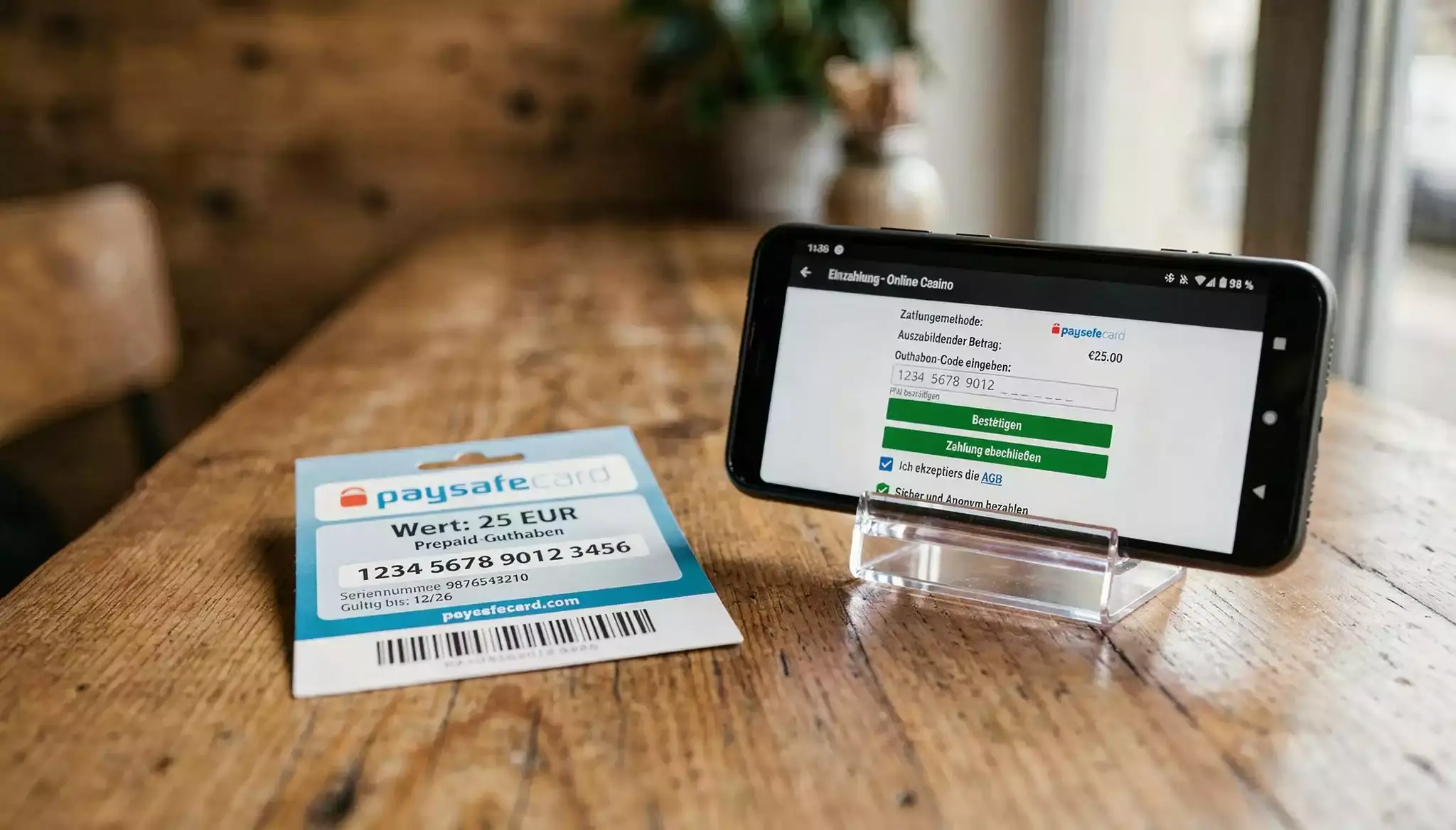 Zehn-Euro-Paysafecard-Voucher neben einem Smartphone mit geöffnetem Casino-Kassenbereich